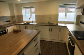 A kitchen with two ovens and hobs, two sinks, and lots of drawers and cupboards.