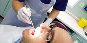 Dental professional looking in patient's mouth.
