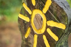 Simple image of a yellow sun painted on a wooden pole in Costa Rica