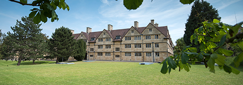 An accommodation block set in a green area and surrounded by trees.