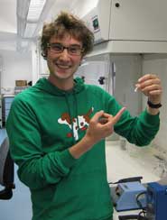 Nick Crumpton holding a specimen tube containing a molar tooth belonging to the early mammal, Morganucodon