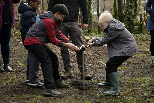 Image of archaeologists and school children working together