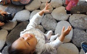 Child on pebble mat
