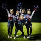 Group of girls posing on a field at night, wearing cheerleading uniforms. Image links to Cheerleading Club page on Bristol SU website.