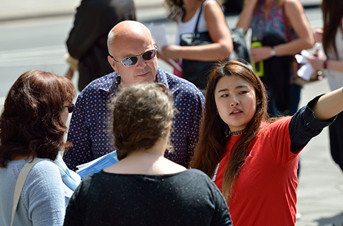 A student ambassador giving directions to a visitor and their parents/supporters at a visit day.