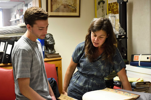 2 people looking at a book together.