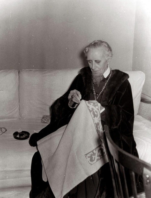 Ernest Thesiger as in costume as Polonius, backstage working on a piece of embroidery