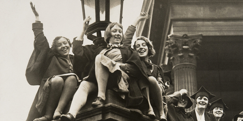A photograph from around 1920 showing female students cheering.