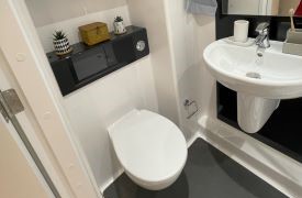 A white toilet next to a sink against a wall.
