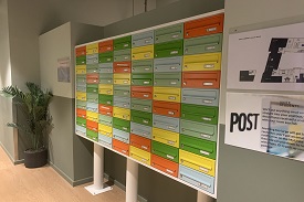 Multicoloured post boxes for students post in the downstairs corridor of Campbell House.