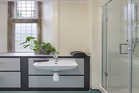 A bathroom with a sink and shower cubicle.
