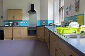 A kitchen with two sinks, an oven and hob, and lots of cupboards and drawers.