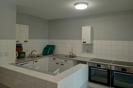 A kitchen with two ovens and hobs, a fridge and freezer, and lots of cupboard and drawers.
