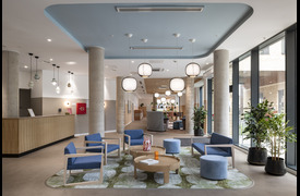A reception area showing a coffee table, chairs and decorative trees.