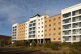Large building with green space in the foreground.