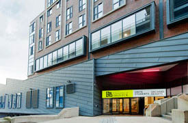 The exterior of a modern multi-storey building. There is a sign at the entrance saying 'University of Bristol, Unite Students, Orchard Heights'.