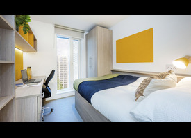 A modern bedroom with a double bed, study desk, shelving, fitted wardrobe and floor-to-ceiling window.&rdquo;