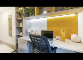 A desk, chair, shelving, storage drawers and integrated lighting in a modern student bedroom.&rdquo;