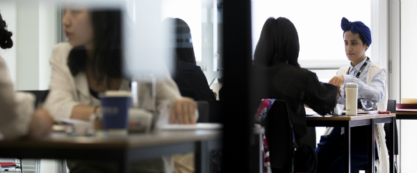 Female students sit in a classroom.