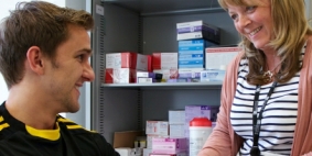 A man and a woman talking in front of a medicine cabinet
