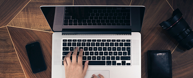 A birds-eye view of a hand typing on a laptop
