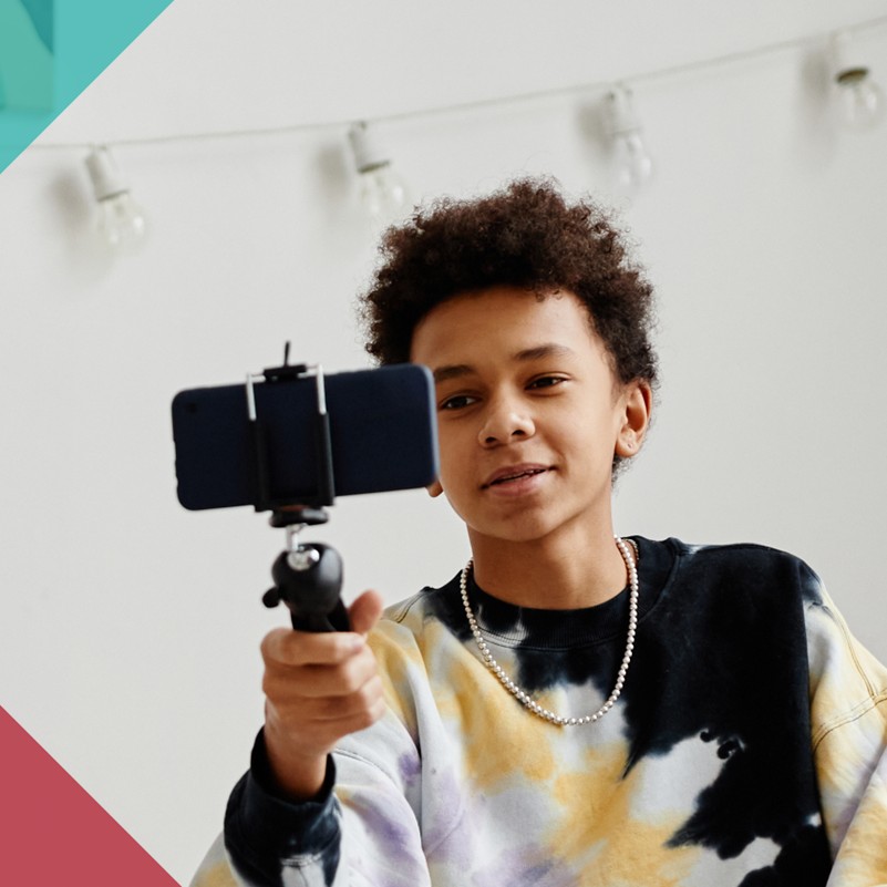 a child holding a selfie stick with a mobile phone attached