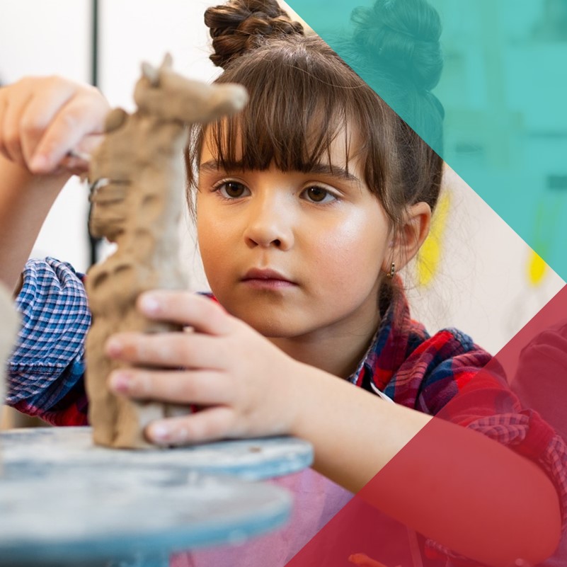 A young child making a pottery sculpture