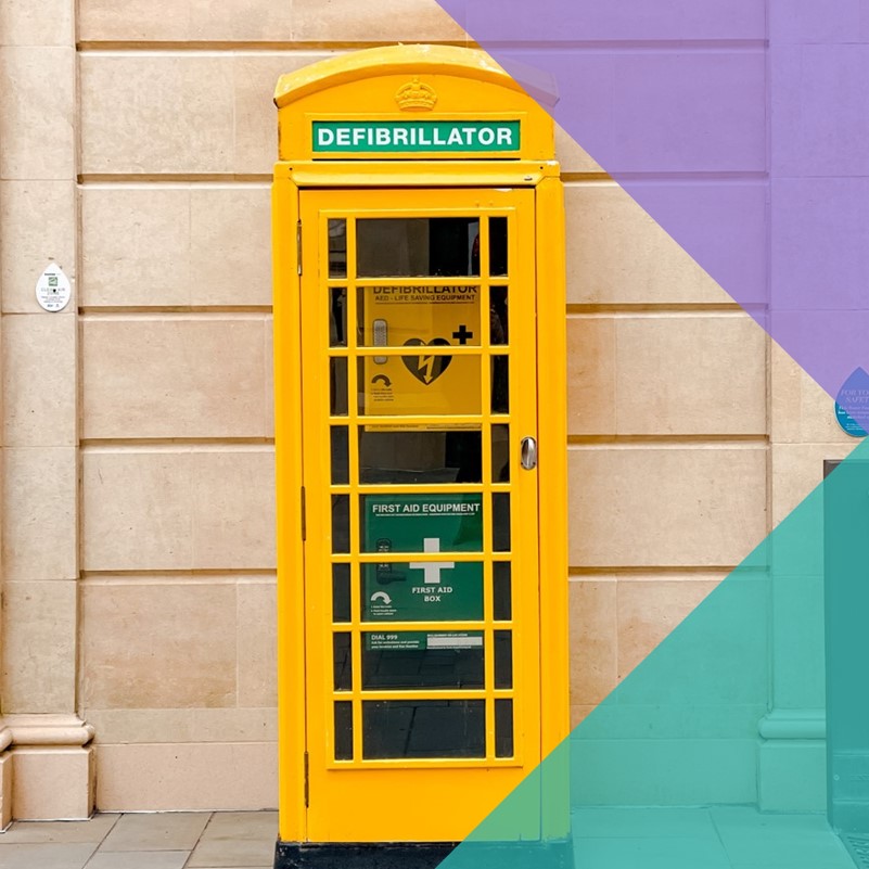 A photo of a yellow 'phone box' that houses a AED (defibrillator)