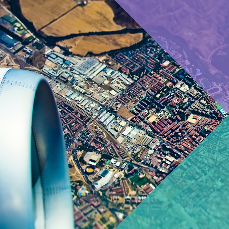 A satellite photo of a dense city next to a range of hills and mountains