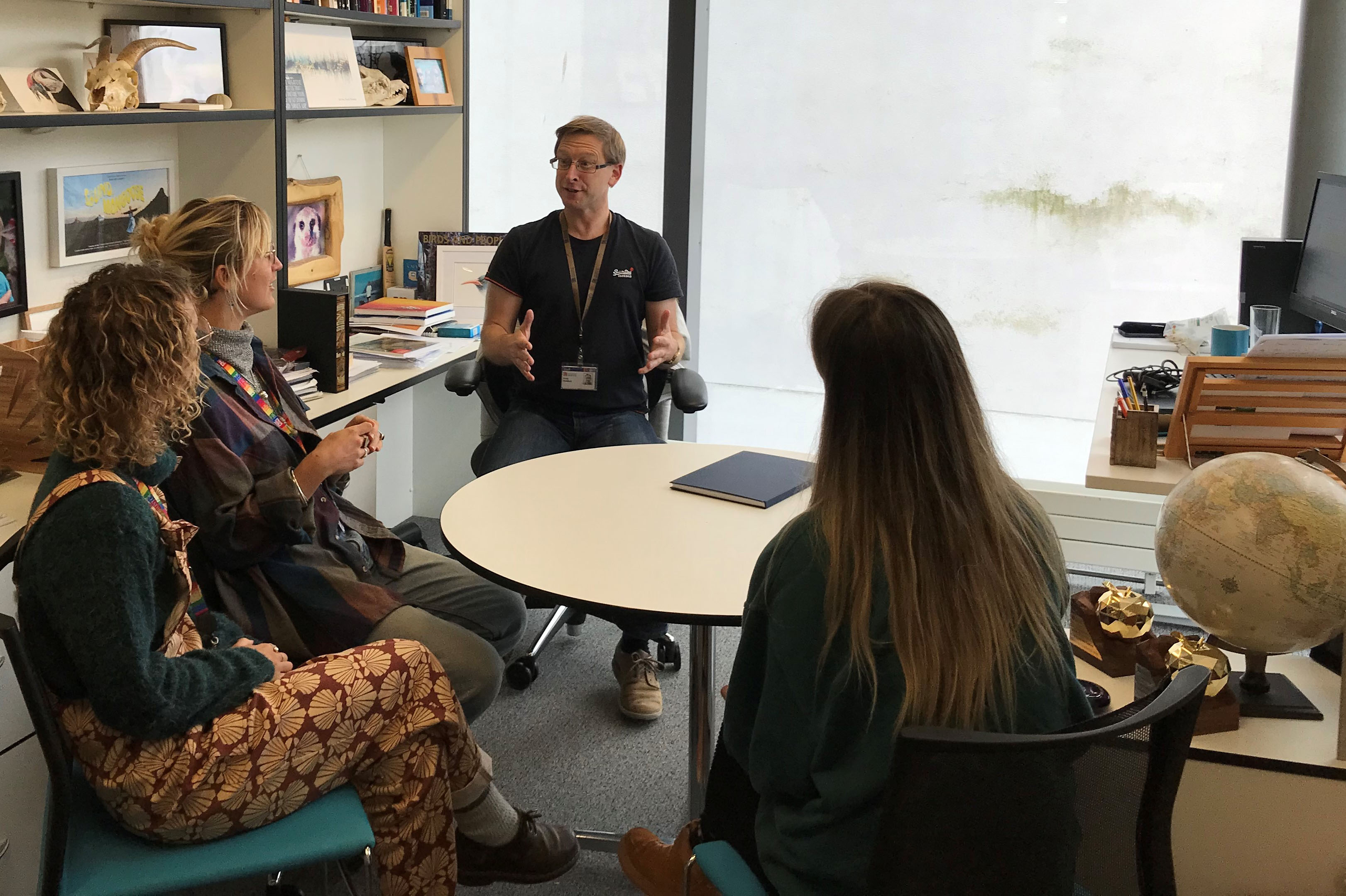 Andy Radford sits with a group of students around a coffee table