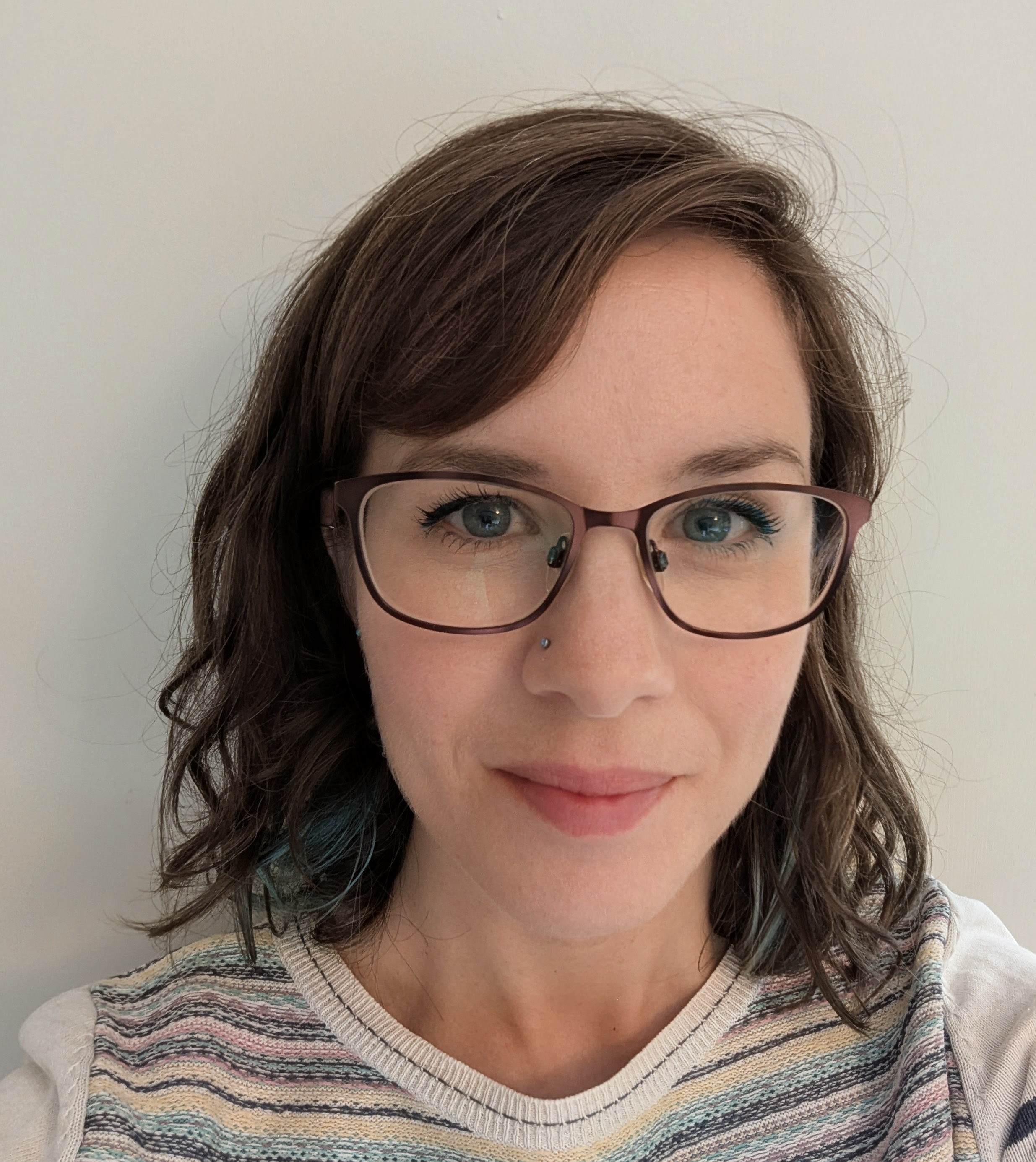 Head shot of young woman with dark hair and glasses facing the camera