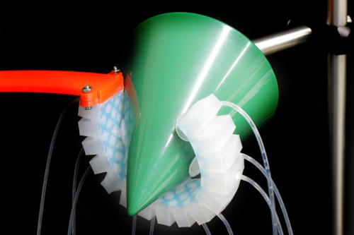 Suction cups using suction intelligence to grasp a cone shaped object.