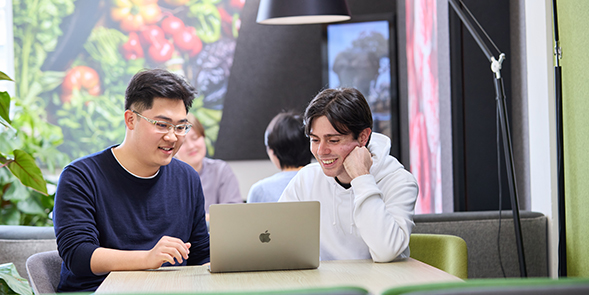 two students looking at a laptop on campus
