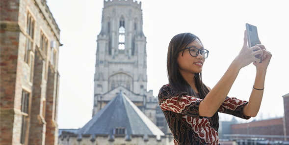 a student taking a selfie in front of Will's Memorial Building