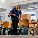A lady hoovering in a large room