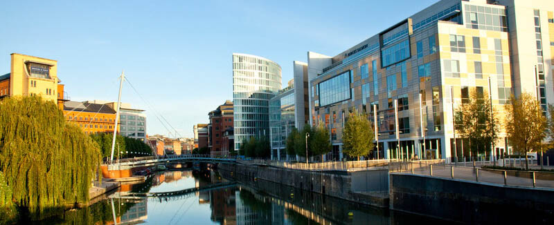 the river at temple quay with a pedestrian bridge ahead and corporate buildings on the right hand side