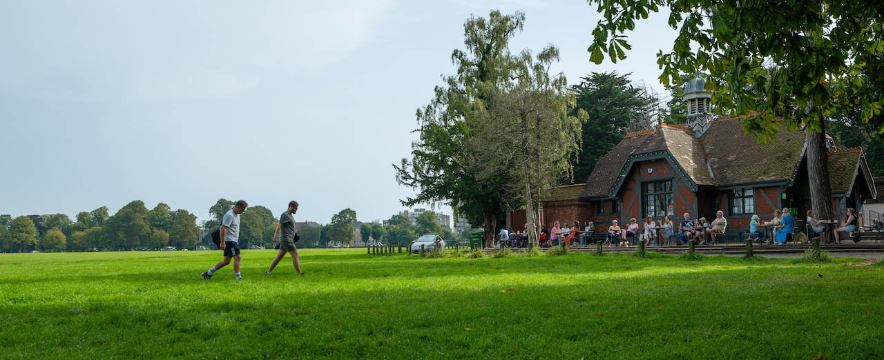 a shot of clifton downs, with trees and the cafe on the right and a line of trees in the background
