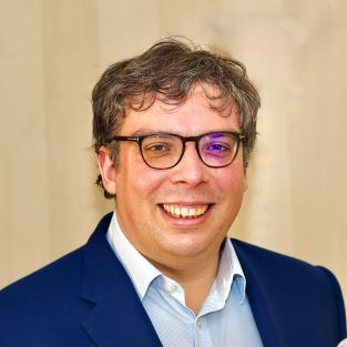 a head and shoulders portrait of Thomas smiling