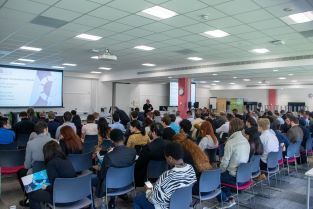 Wide shot of delegates watching presentations at the 2023 BCI Doctoral Research Symposium