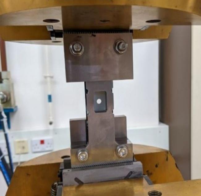 a carbon/epoxy composite sample being tested under uniaxial compression at cross head speed of 1 mm/min