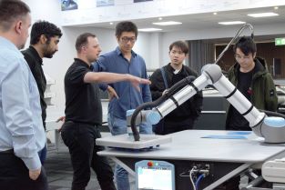 BCI researchers being shown robotic offloading of digital cut parts during a site visit of Zund UK
