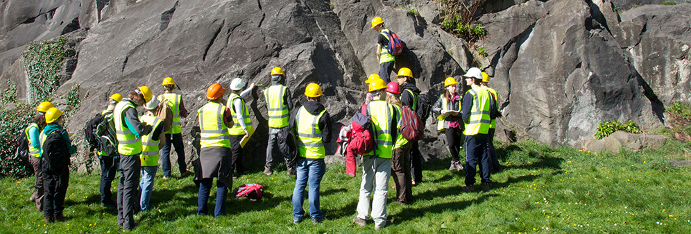 Students undertaking fieldwork at the base of a cliff.