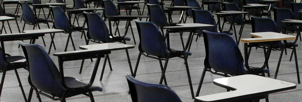 Rows of empty school chairs and desks.