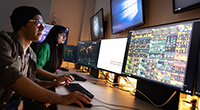 Students in front of screens in dark room