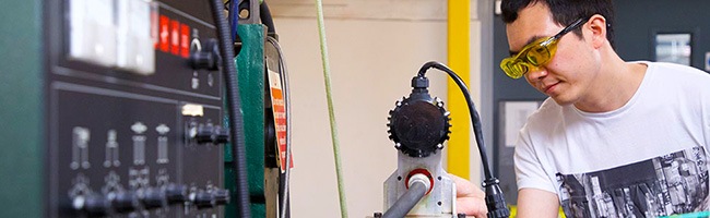 Mechanical engineering student working on a piece of a equipment