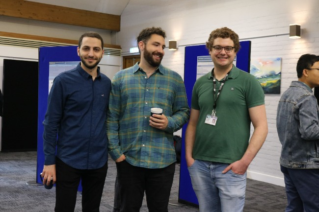 Three postgraduate students smiling for the camera.