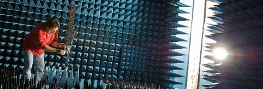 Researcher measuring 3D antenna radiation in anechoic chamber