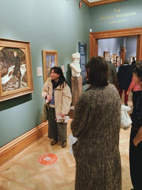 Dr Deborah Lam explaining painting to seminar group in a museum
