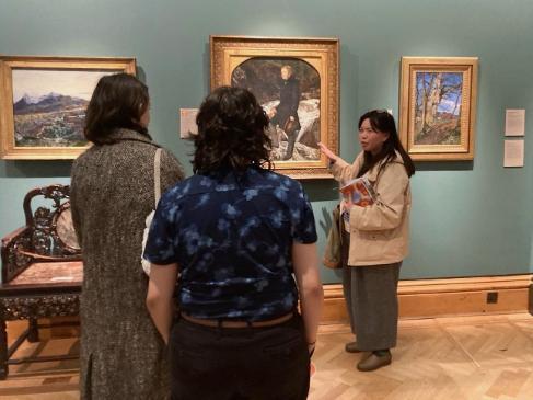 Dr Deborah Lam explaining painting to seminar group in a museum