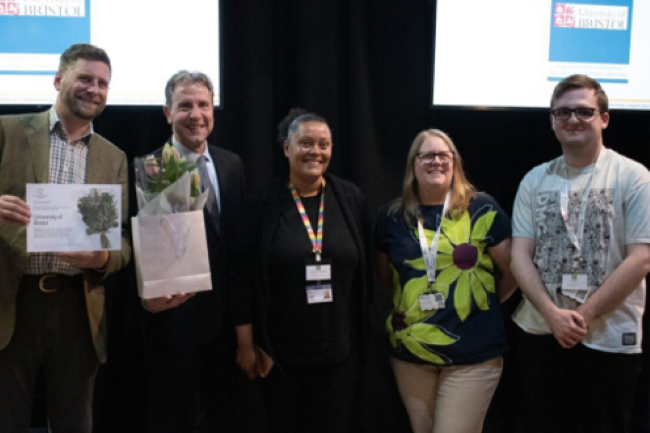 Four people smiling with certificates